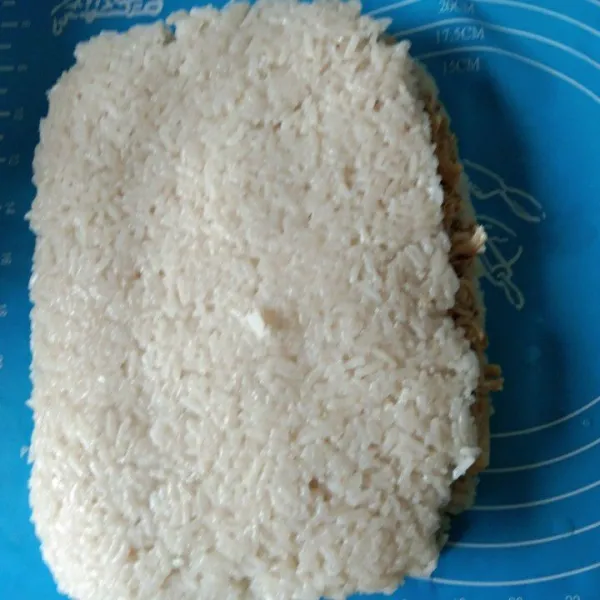 Tuang suwiran ayam di salah satu bagian beras ketan, tutup atasnya dengan beras ketan satu lagi.