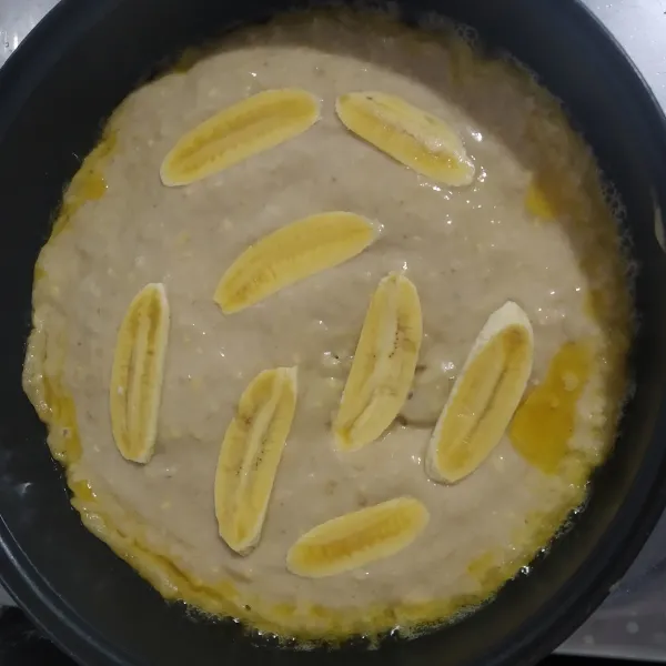 Panaskan teflon olesi secukupnya margarin lalu tuang adonan dan ratakan, kemudian beri irisan pisang di atasnya masak dengan api kecil jika sudah berubah warna balik ke sisih satunya secara perlahan.