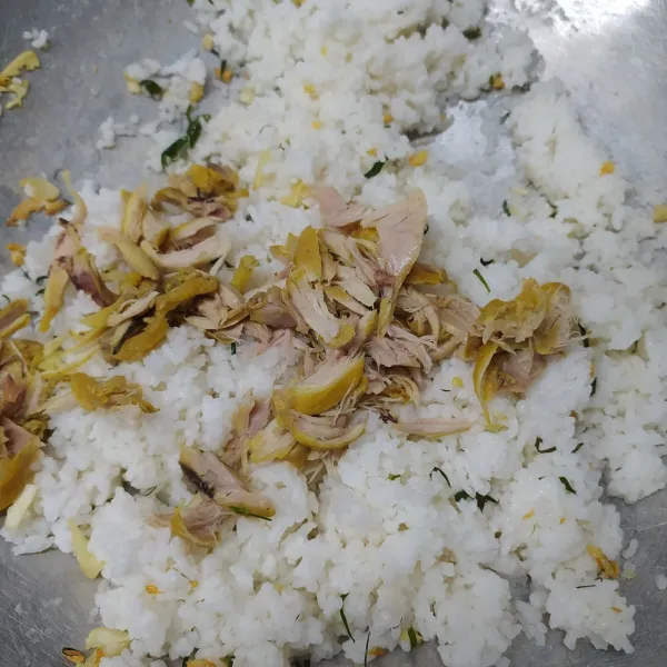 Masukan nasi dan suwiran ayam, aduk sampai rata, sisihkan nasi di samping wajan