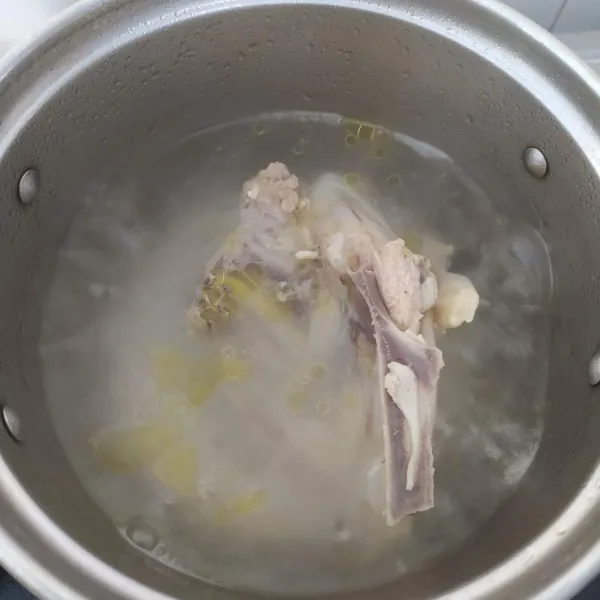 Cuci bersih ayam, kemudian rebus dengan api kecil, supaya kaldunya keluar.