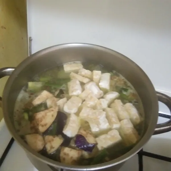 Masukan irisan tempe dan terong ungu masak hingga terong ungu berubah warna