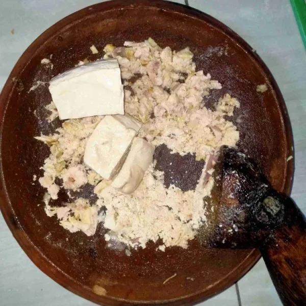 Masukkan tahu lalu uleg, aduk rata.