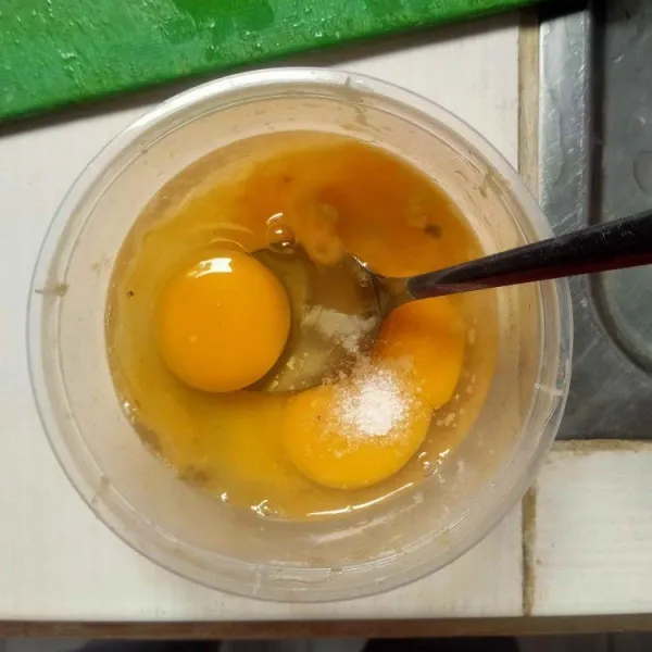 Siapkan 2 telur. Tambahkan garam dan kaldu jamur, aduk rata.
