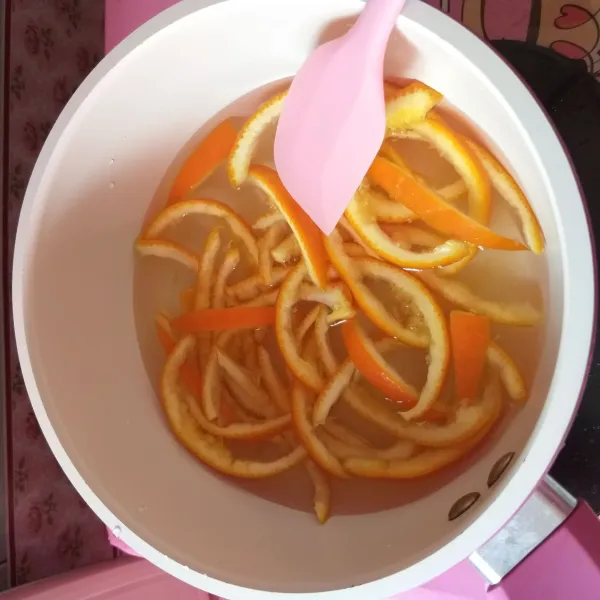 Panaskan air dan gula, kemudian masukan irisan kulit jeruk sunkist. Masak hingga air menyusut.