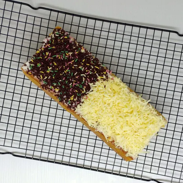 Oles butter cream diatas cake, beri taburan keju separuh dan coklat separuh, potong-potong dan sajikan.