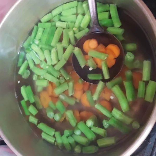 Rebus air (bisa diganti kaldu) hingga mendidih. Masukkan irisan wortel dan buncis.