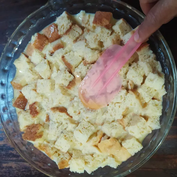 Tekan-tekan adonan dengan spatula hingga susu terserap oleh roti.