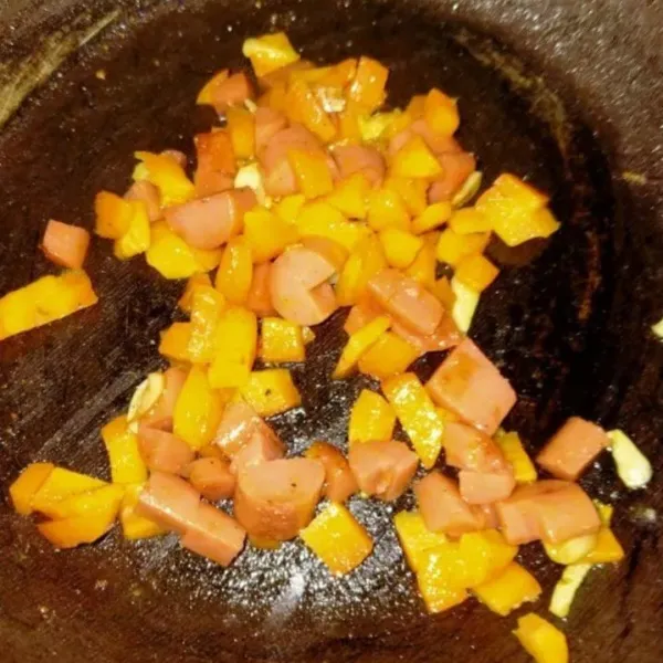 Panaskan teflon beri mentega masukkan bawang putih cincang tunggu hingga harum masukkan kentang dan sosis beri garam dan merica bubuk.