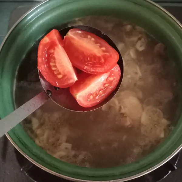 Tambahkan garam dan tomat ke dalam kuah lalu masak kembali hingga matang.