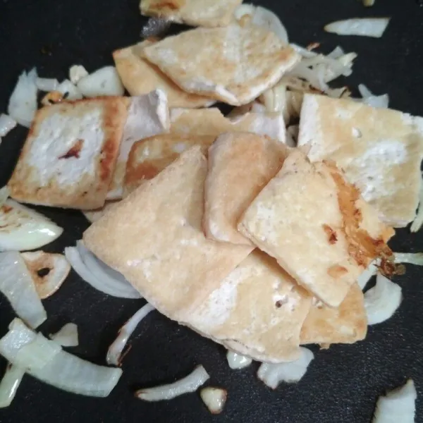 Tumis bawang putih dan bawang bombay hingga kecoklatan, tambahkan tahu yang sudah dipanggang tadi