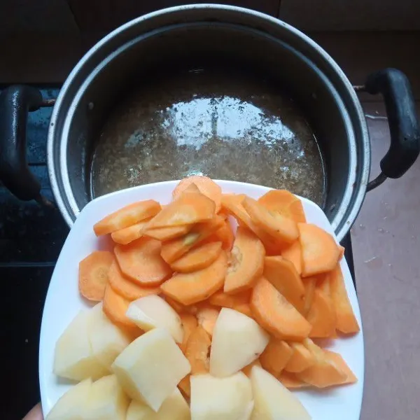 Rebus bersama wortel, kentang, garam dan penyedap rasa bila suka, sampai agak lunak.