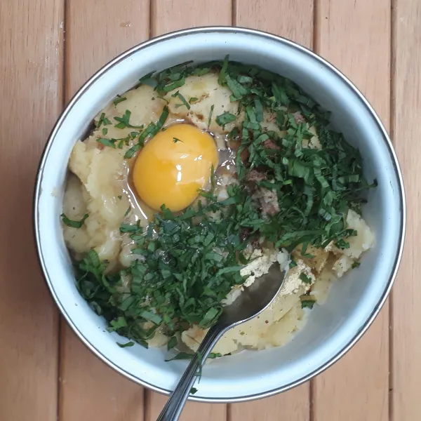 Masukkan ke dalam mangkuk : kentang tumbuk, 1 butir telur, daun seledri, bumbu halus, pala bubuk, kaldu jamur bubuk dan garam. Aduk hingga rata.