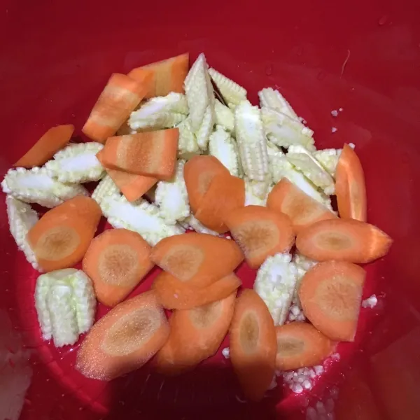 Kupas wortel, potong serong. Cuci jagung muda, potong serong.