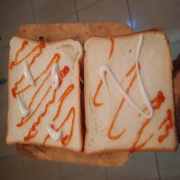 Oleskan saos sambal dan mayonais keatas roti tawar.