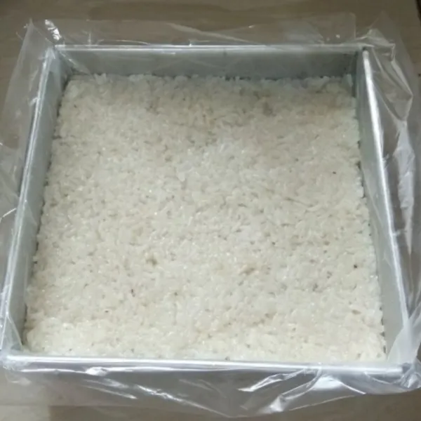 Masukan lagi nasi ketan sambil dipadatkan. Isi loyangnya hingga penuh. Tutupi permukaannya dengan plastik agar permukaan nasi ketannya tidak mengering. Biarkan dingin.