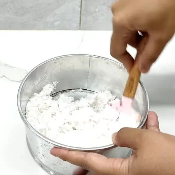 Campurkan kelapa parut dan garam, lalu aduk menggunakan spatula.