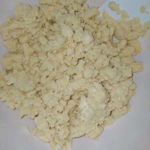Masukkan campuran tepung ke campuran margarin hingga beremah, jangan dipadatkan