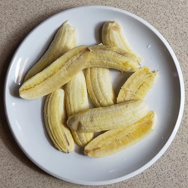 Siapkan pisang uli lalu belah menjadi dua bagian.