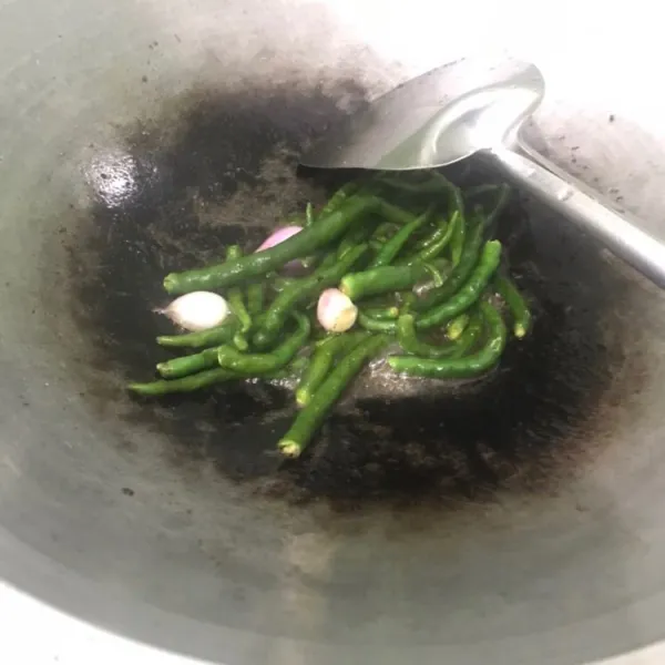 Membuat sambal hijau: tumis cabe dan bawang setengah matang.
