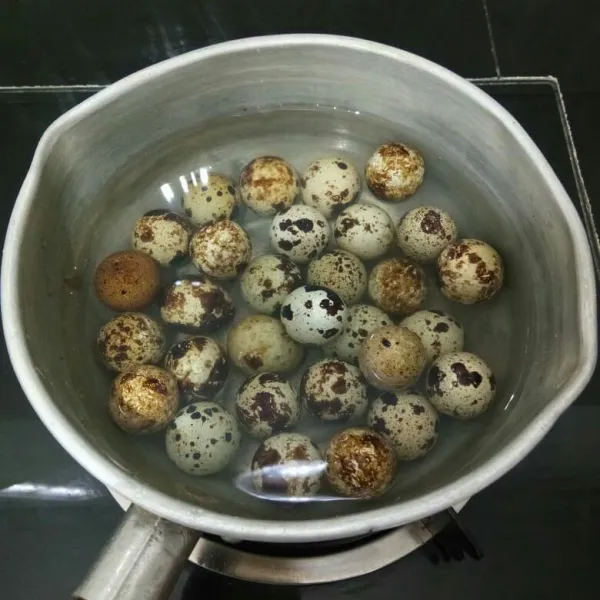 Rebus telur puyuh hingga matang, lalu kupas.