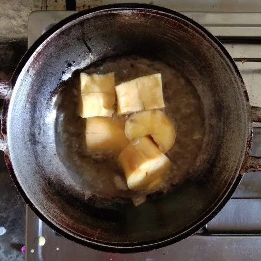 Goreng singkong dengan minyak goreng hingga kecoklatan.