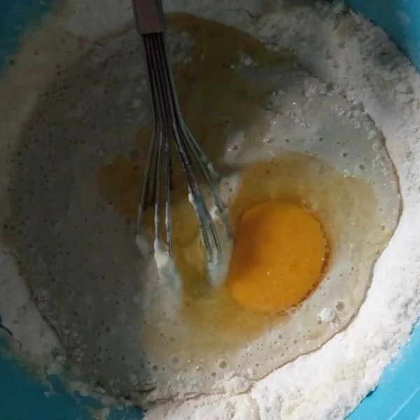 Masukan susu dan telur, aduk dengan whisk hingga semua tercampur rata. Diamkan dan tutupi dengan serbet minimal 30 menit. Lalu tambahkan garam dan minyak goreng, aduk rata