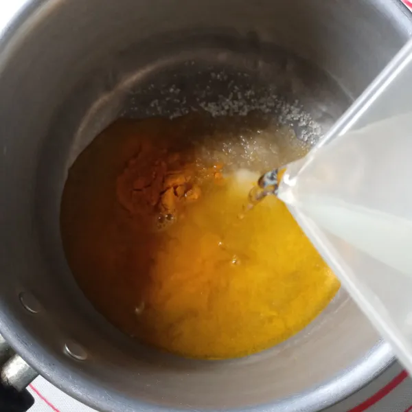 Masukkan garam, gula pasir dan kunyit bubuk kedalam panci. Tuang air, aduk rata.