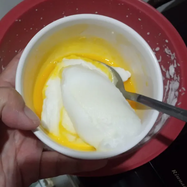 Masukkan 1sdm adonan putih telur ke dalam kuning telur. Aduk rata.