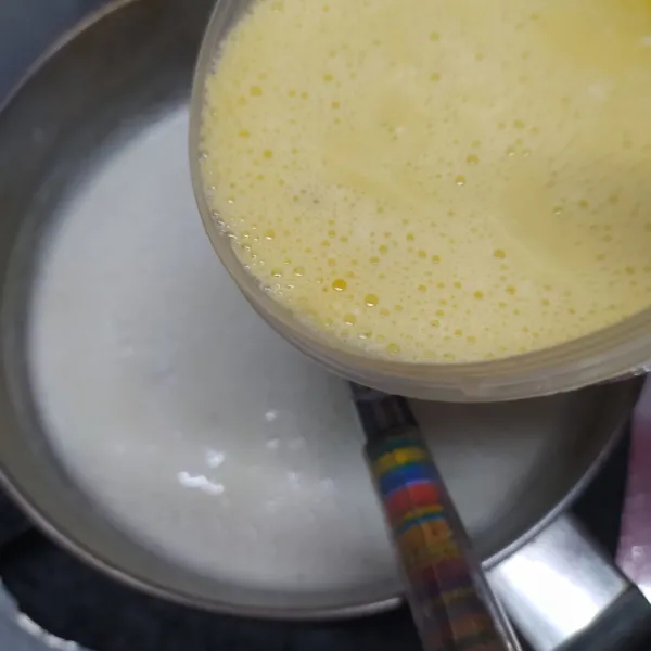 Masukkan campuran puding kocokan telur ke dalam panci puding, tambahkan ekstrak vanila. Rebus kembali sambil diaduk-aduk sampai mendidih. Lalu angkat.