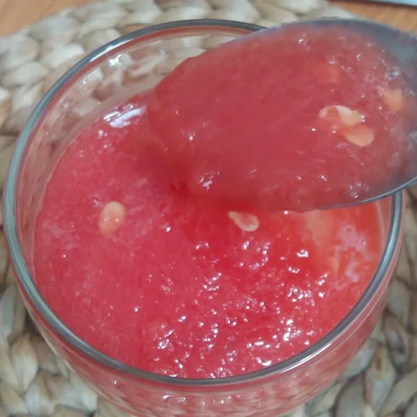 Kemudian semangka yang sudah di blender dimasukkan ke dalam gelas dengan memakai sendok.