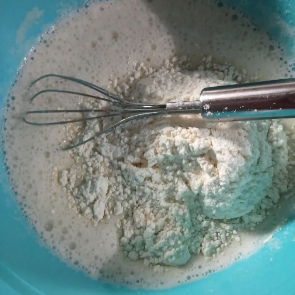 Tambahkan tepung sedikit demi sedikit, kocok hingga licin dan tidak bergerindil. Masukkan baking powder dan perisa vanilla, aduk rata.