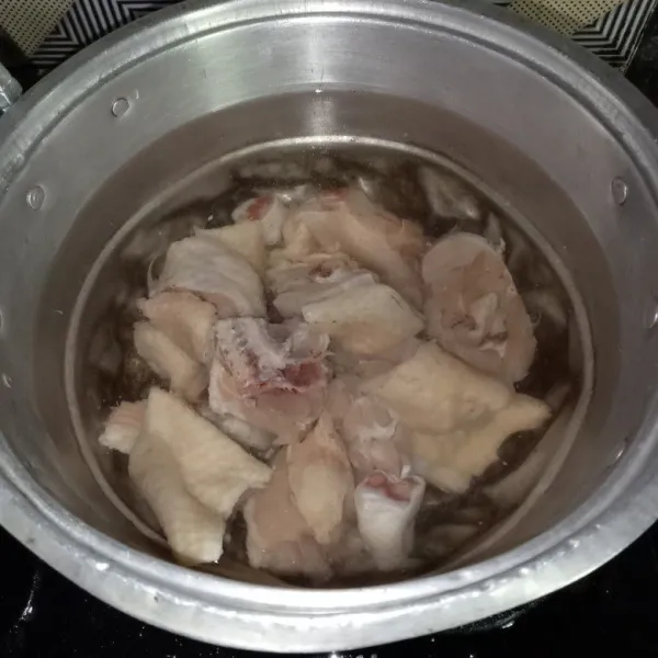 Masukkan air dan ayam yang sudah dipotong-potong ke dalam panci, lalu rebus hingga mendidih.