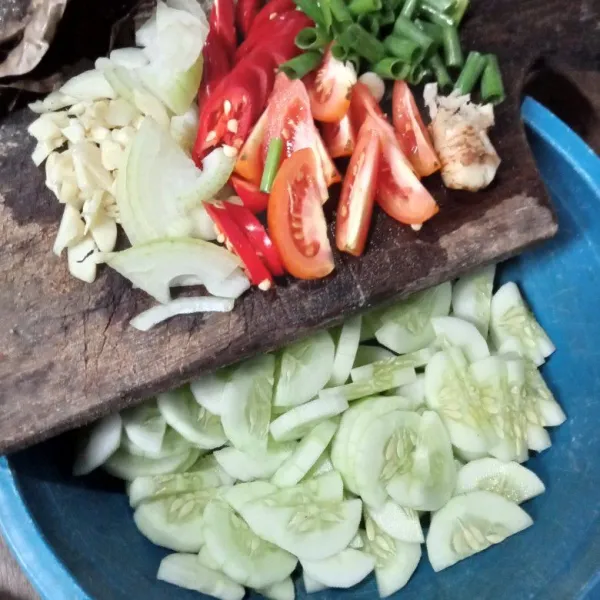 Kupas mentimun dan potong-potong. Cincang bawang putih. Potong-potong tomat, cabai, bawang bombai dan daun bawang.