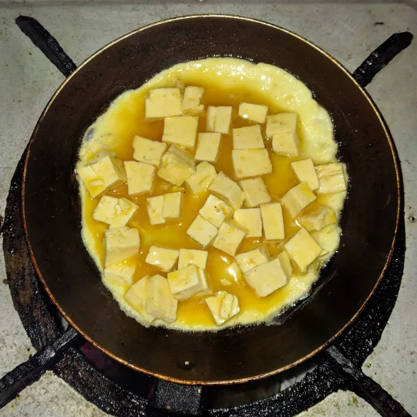Panaskan teflon, beri minyak goreng dan masukkan telur hingga kecoklatan dan balik kedua sisinya.