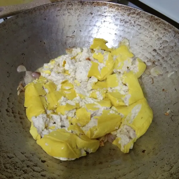 Masukan tahu yang telah dihancurkan, aduk rata.