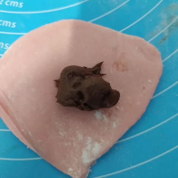 Bagi mochi menjadi beberapa bagian, kemudian gilas, tapi jangan terlalu tipis. Kemudian isi dengan selai coklat.