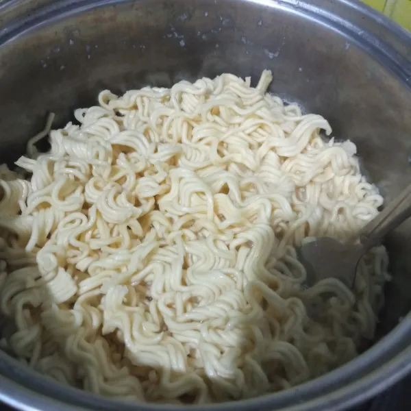 Rebus mie, tambahkan 1 sdm minyak goreng agar mie tidak saling menempel, masak hingga mie setengah matang, tiriskan.