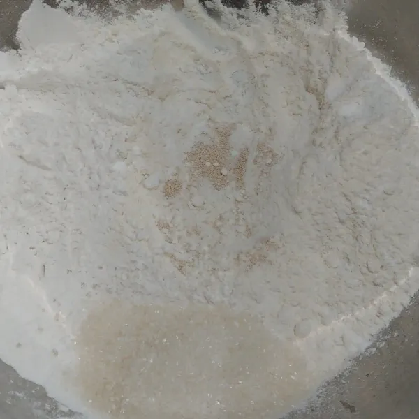 Campur jadi satu dalam wadah tepung terigu, tepung beras, ragi dan gula pasir.