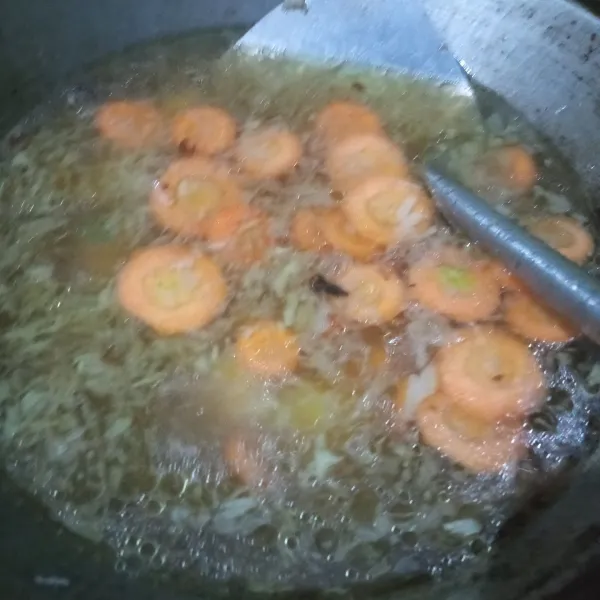 Tambahkan air, masak hingga kuah mendidih. Masukan kentang dan wortel, masak hingga empuk
