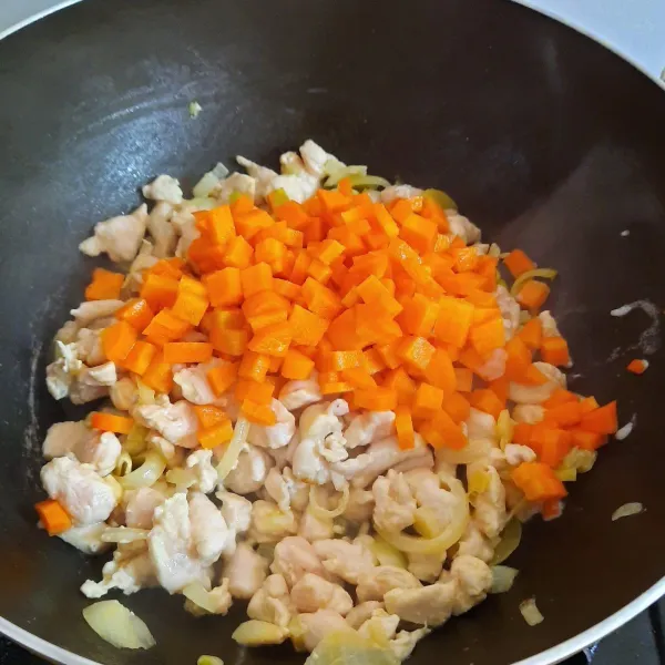 Masukkan ayam fillet cincang. Masak hingga ayam berubah warna. Masukkan wortel yang dipotong kotak. Masak sebentar hingga daging dan wortel matang.