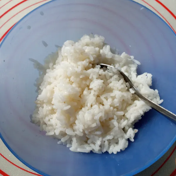 Tuang larutan air, cuka makan, gula diet, dan garam tadi ke nasi panas. Aduk rata.