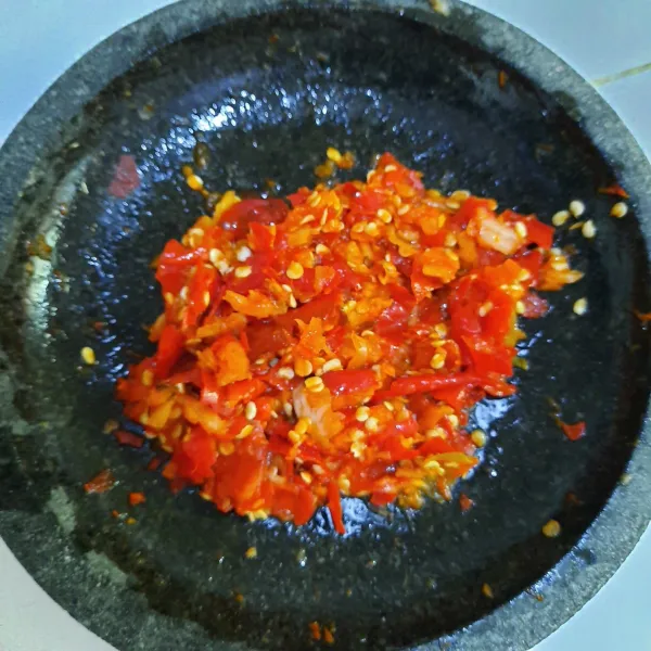 Membuat sambal mentah: masukan semua bahan sambel dalam cobek lalu ulek. Sajikan sambel mentah bersama ikan goreng.