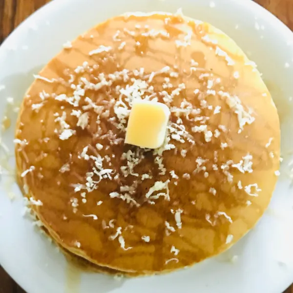 Jika semua pancake telah selesai, susun secara bertingkat lalu beri toping sirup mapel dan keju atau bisa sesuai selera.