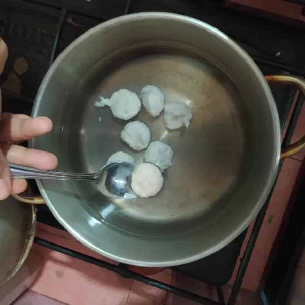 Siapkan panci berisi air panas, kecilkan apinya. Cetak bakso menggunakan tangan dan bantuan sendok, masukan ke air panas.