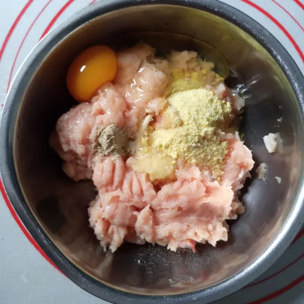 Haluskan ayam dan bawang putih. Masukkan telur, kaldu ayam bubuk, lada dan daun bawang. Aduk rata.
