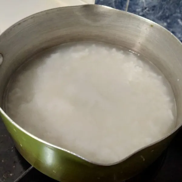 Untuk membuat bubur, masukkan beras dan air ke dalam panci.
