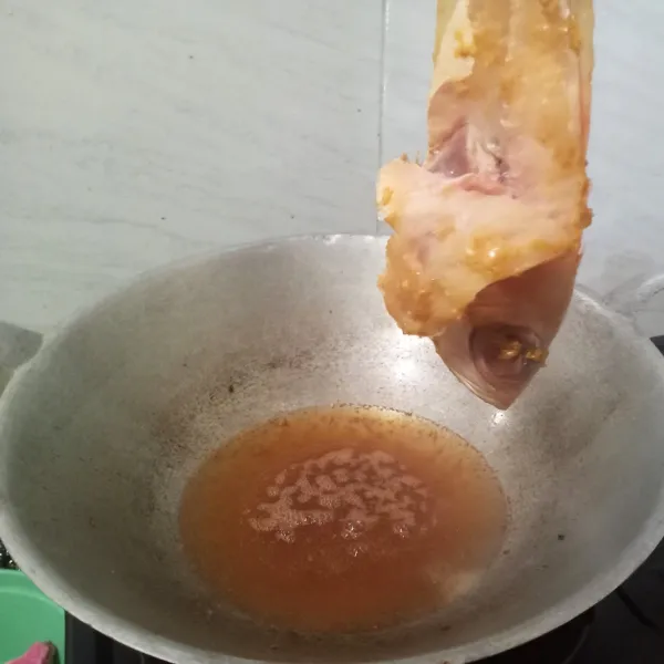 Goreng ikan kakap dengan minyak panas.