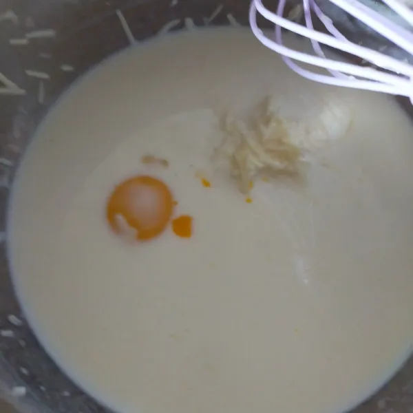 Tuang susu cair dalam panci, beri keju cheddar dan kuning telur. Aduk rata.