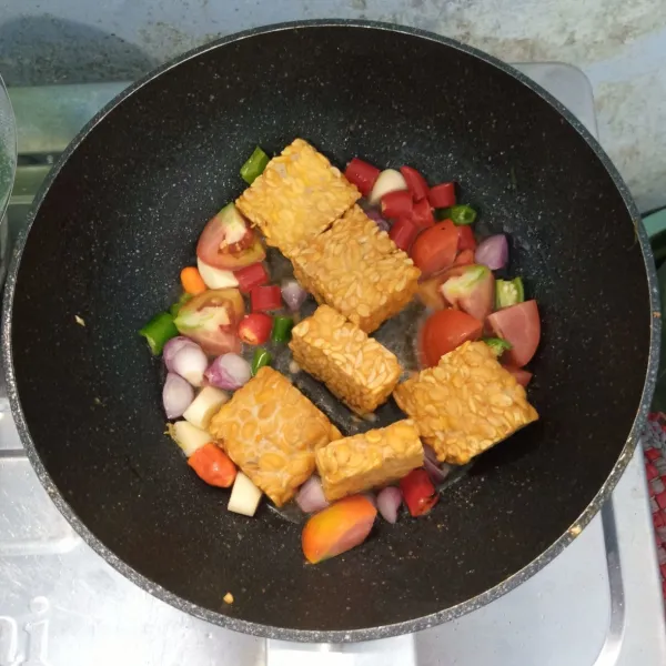 Goreng bawang merah, bawang putih, cabai merah, cabai hijau besar, cabai rawit, tomat dan tempe sampai matang.