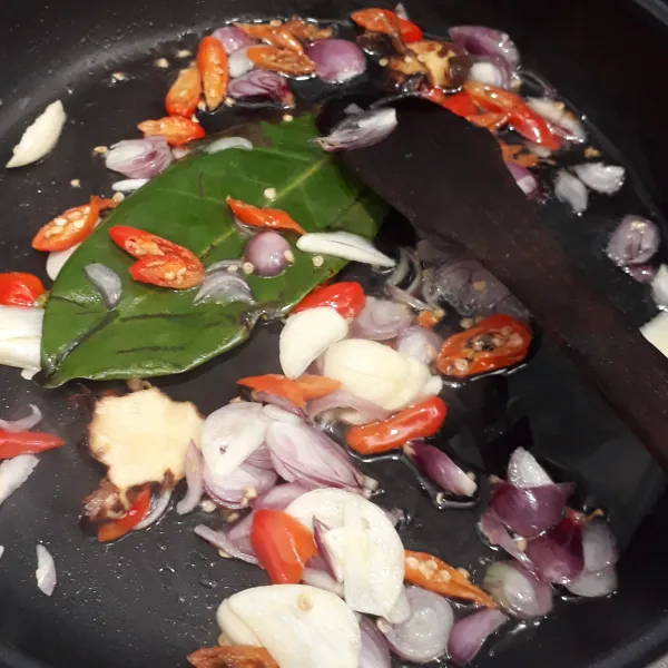 Panaskan minyak goreng lalu tumis bumbu iris bersama daun salam dan lengkuas hingga harum.